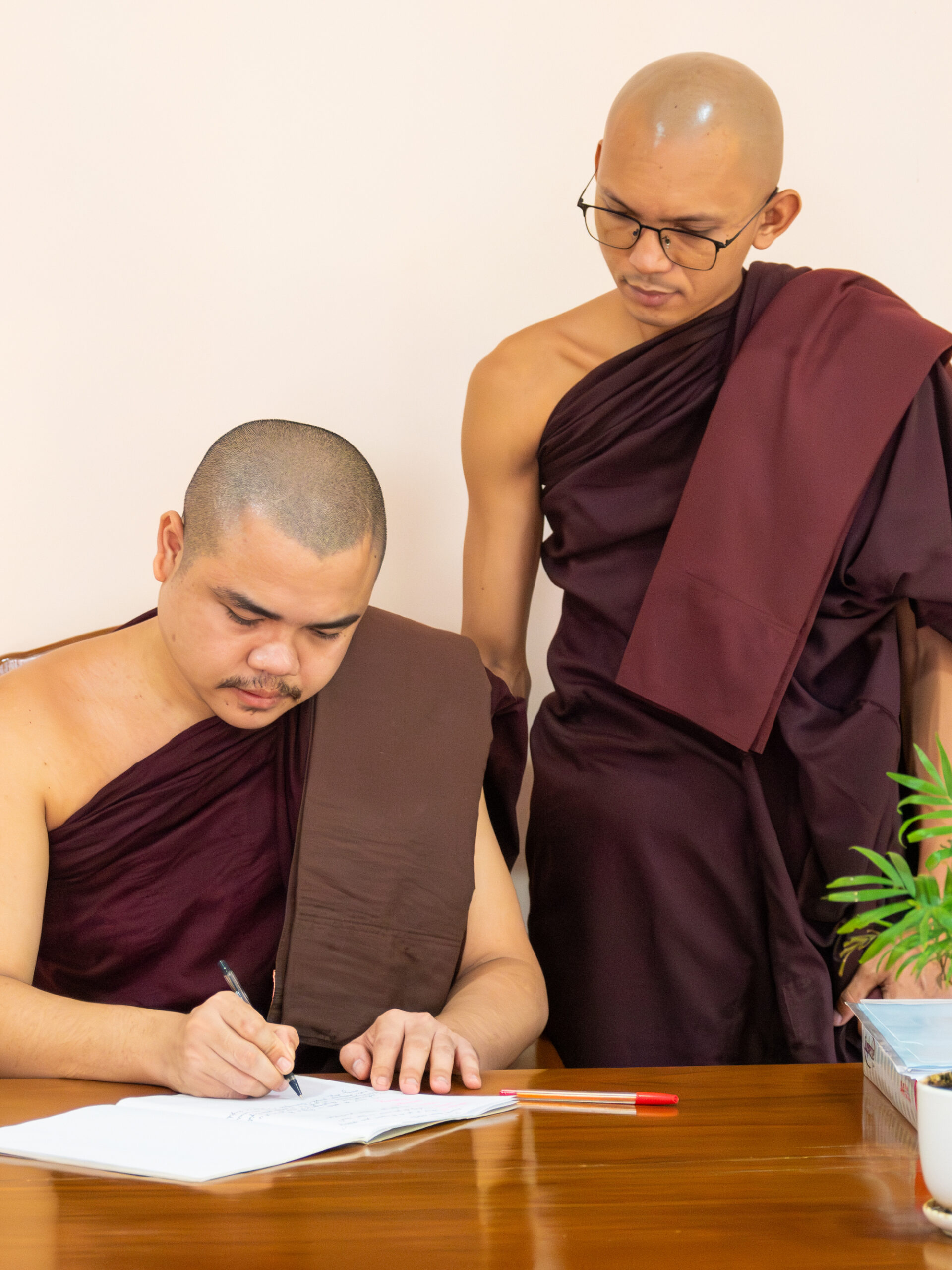 Two monastics working together on academic writing