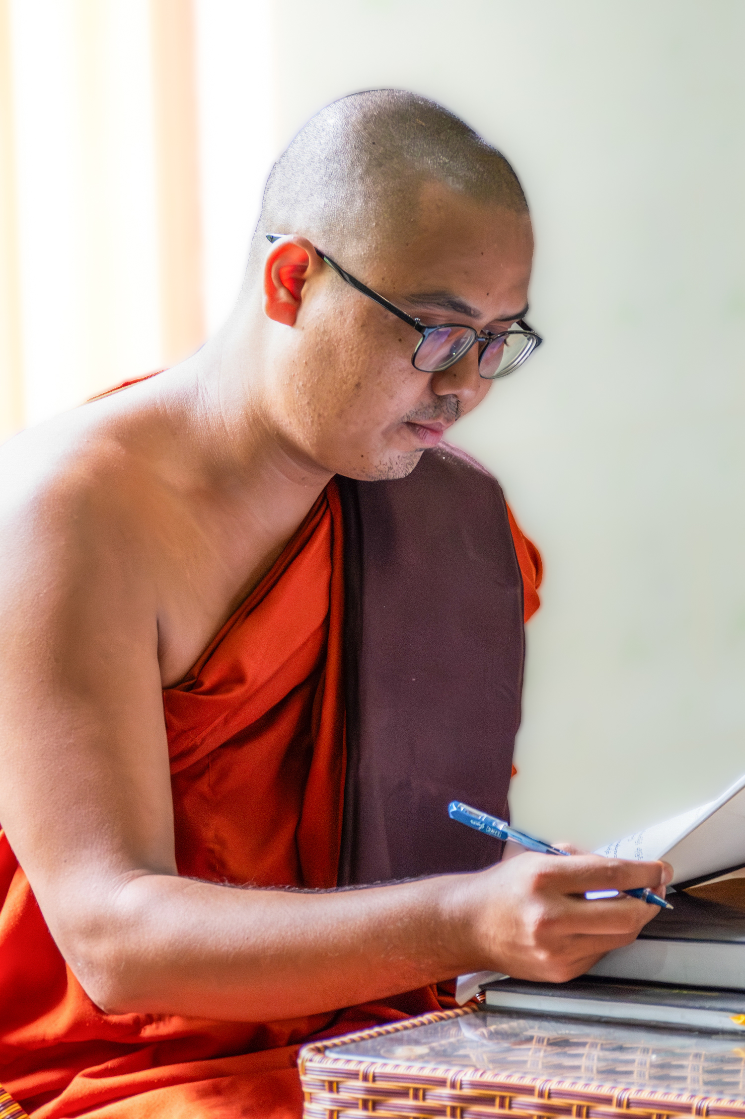 Monastic student reviewing notes at a desk
